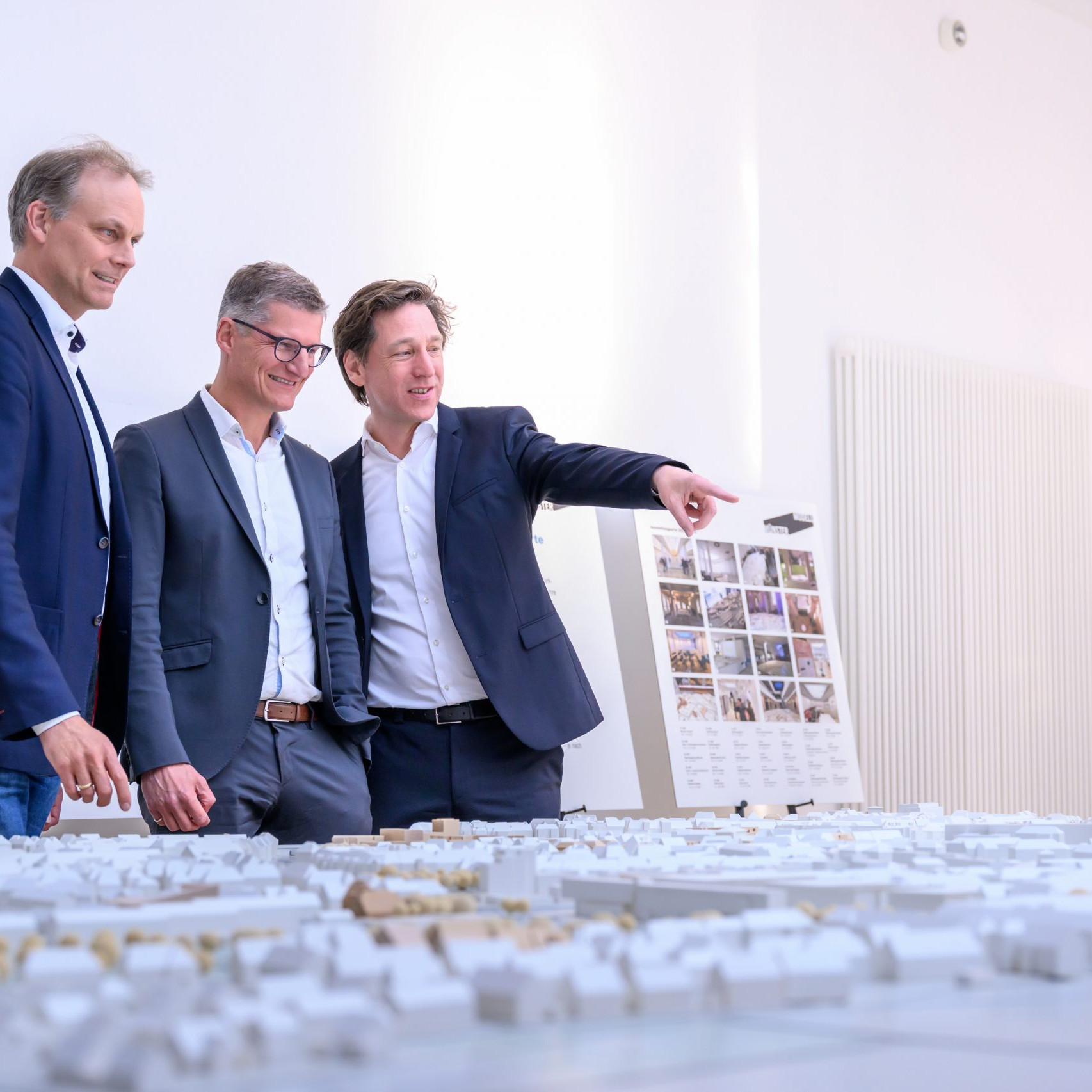 Oberbürgermeister Tilman Fuchs (M.) ließ sich bei der Eröffnung der Ausstellung „Münster Modell – 20 Jahre Forum für Baukultur“ das Münster-Modell vom Vorsitzenden des Vereins Münster Modell e.V., Stefan Rethfeld (r.), und Christopher Festersen, Leiter des Stadtplanungsamtes und Vorstandsmitglied, zeigen. © Stadt Münster / Michael Möller