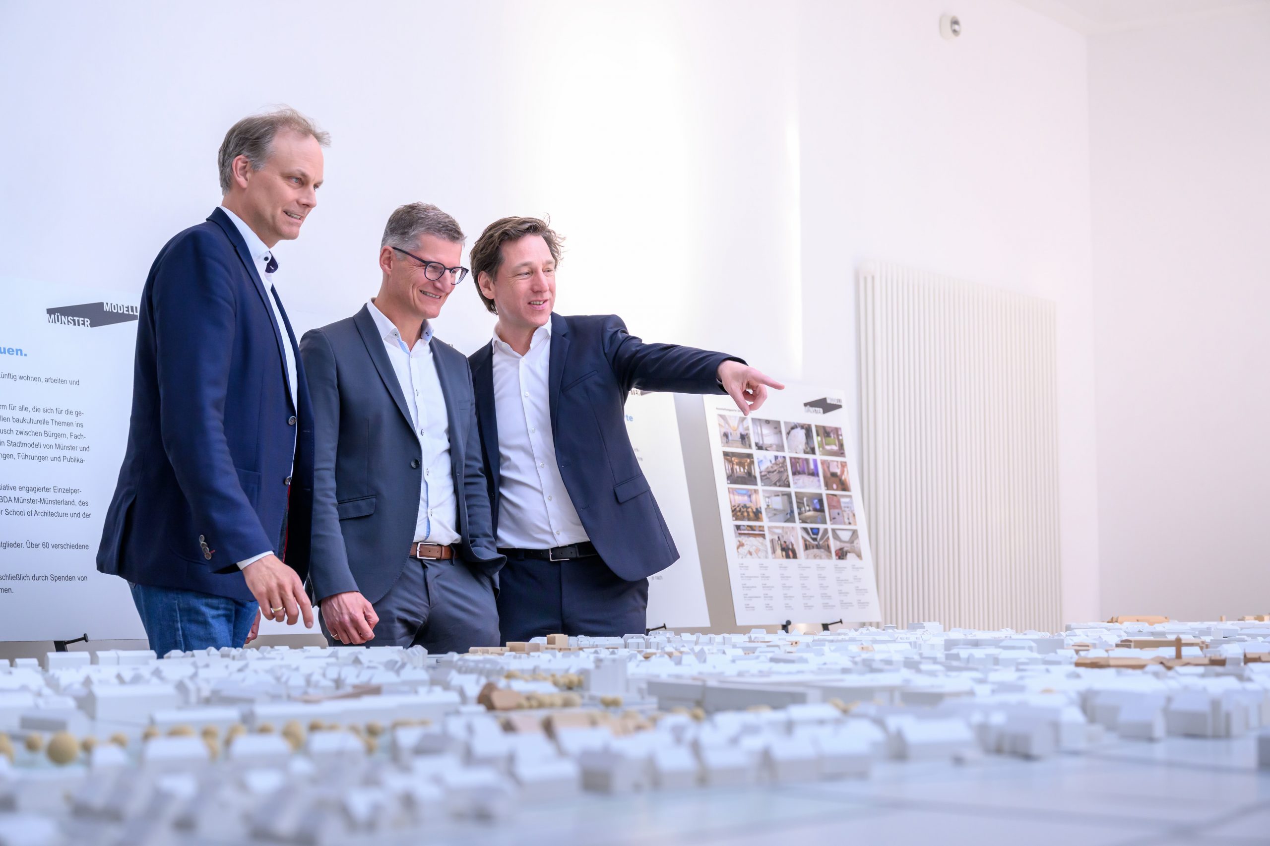 Oberbürgermeister Tilman Fuchs (M.) ließ sich bei der Eröffnung der Ausstellung „Münster Modell – 20 Jahre Forum für Baukultur“ das Münster-Modell vom Vorsitzenden des Vereins Münster Modell e.V., Stefan Rethfeld (r.), und Christopher Festersen, Leiter des Stadtplanungsamtes und Vorstandsmitglied, zeigen. © Stadt Münster / Michael Möller